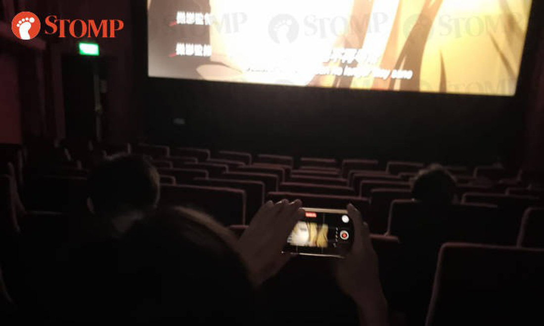 Khán giả dùng điện thoại quay chụp trong khi xem phim - Ảnh: The Straits Times
