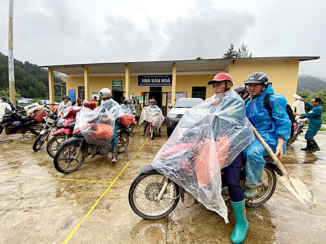 Dân quân tự vệ đi mở đường và cứu trợ với các nhu yếu phẩm thiết yếu cho những hộ dân bị thiệt hại nặng do mưa lũ tại các bản thuộc xã Lao Chải, huyện Mù Cang Chải - Ảnh: C.TUỆ