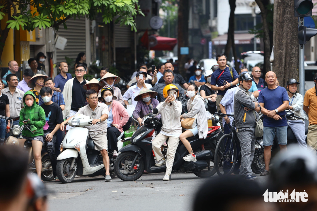 Người dân Hà Nội theo dõi đoàn xe của Tổng thống Mỹ di chuyển trên đường ngày 11-9 - Ảnh: DANH KHANG