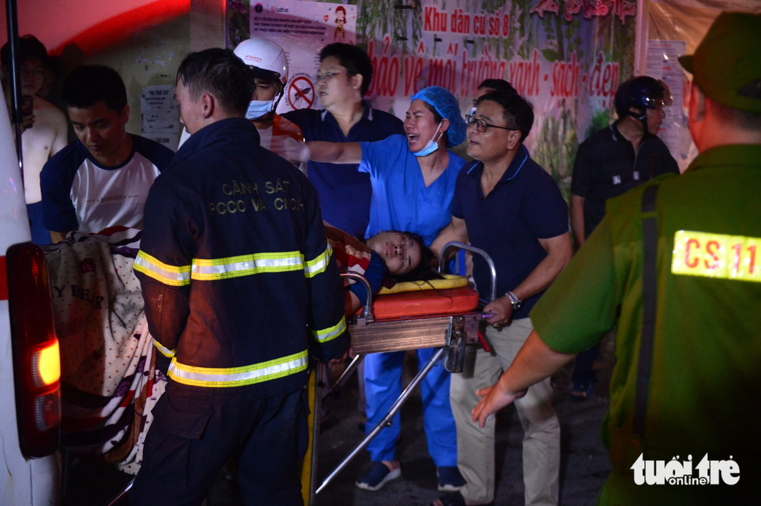 Cảnh sát và nhân viên y tế cùng người dân nỗ lực đưa các nạn nhân đi cấp cứu - Ảnh: DANH TRỌNG