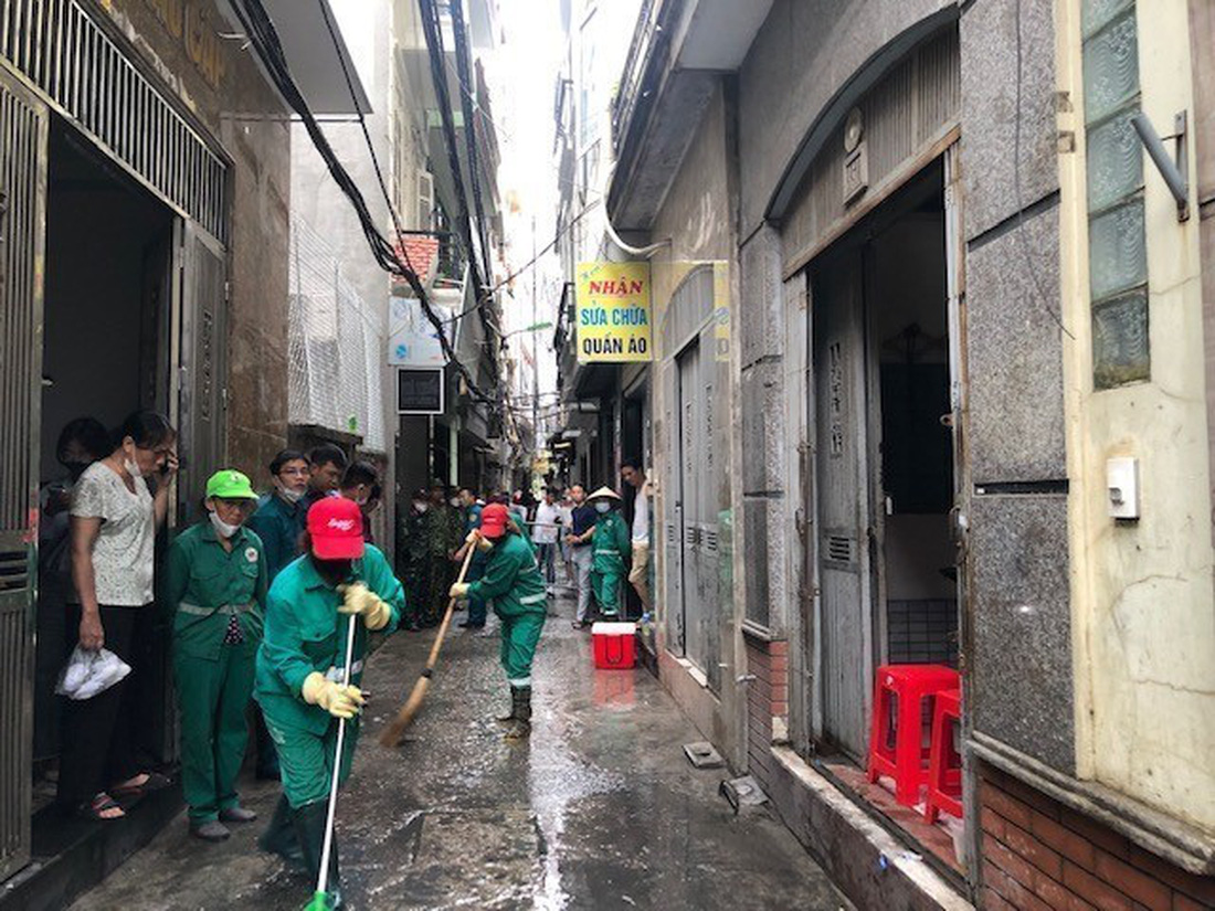 Lực lượng chức năng đã phong tỏa hiện trường, niêm phong tất cả các căn hộ và dọn dẹp vệ sinh khu vực ngõ phía trước tòa nhà xảy ra cháy - Ảnh: TTXVN