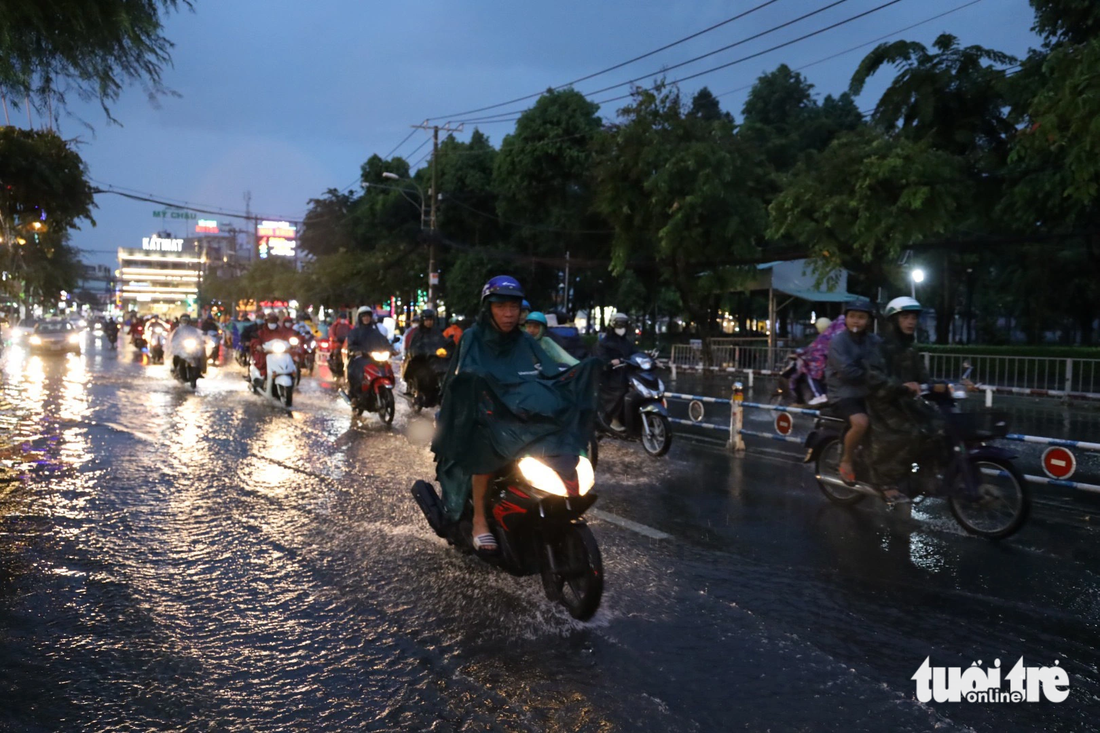 Mưa ngập đường Nguyễn Văn Khối, quận Gò Vấp khiến người dân phải chạy tránh ra sát dải phân cách - Ảnh: NGỌC QUÝ