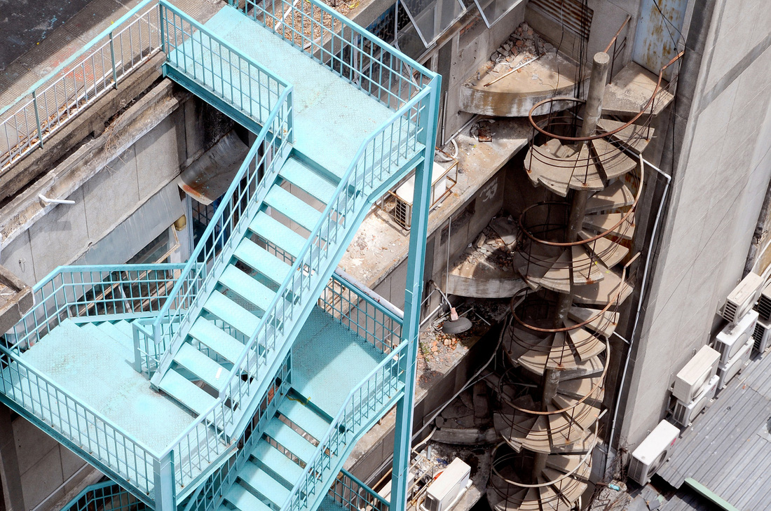 Lối thoát hiểm ngoài trời loại thang sắt kiểu dích dắc xương cá và loại thang xoắn ốc bằng bê tông tại hai tòa cao ốc ở quận 1, TP.HCM - Ảnh: T.T.D.