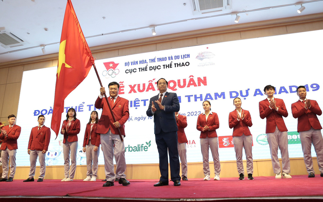 Phó chủ tịch Quốc hội Trần Quang Phương trao cờ cho trưởng đoàn thể thao Việt Nam tại Asiad 19 - Ảnh: HOÀNG TÙNG