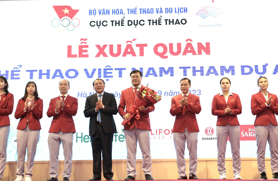 Bộ trưởng Bộ Văn hóa, Thể thao và Du lịch Nguyễn Văn Hùng (áo đen) chúc đoàn thể thao Việt Nam hoàn thành nhiệm vụ trước khi lên đường - Ảnh: HOÀNG TÙNG