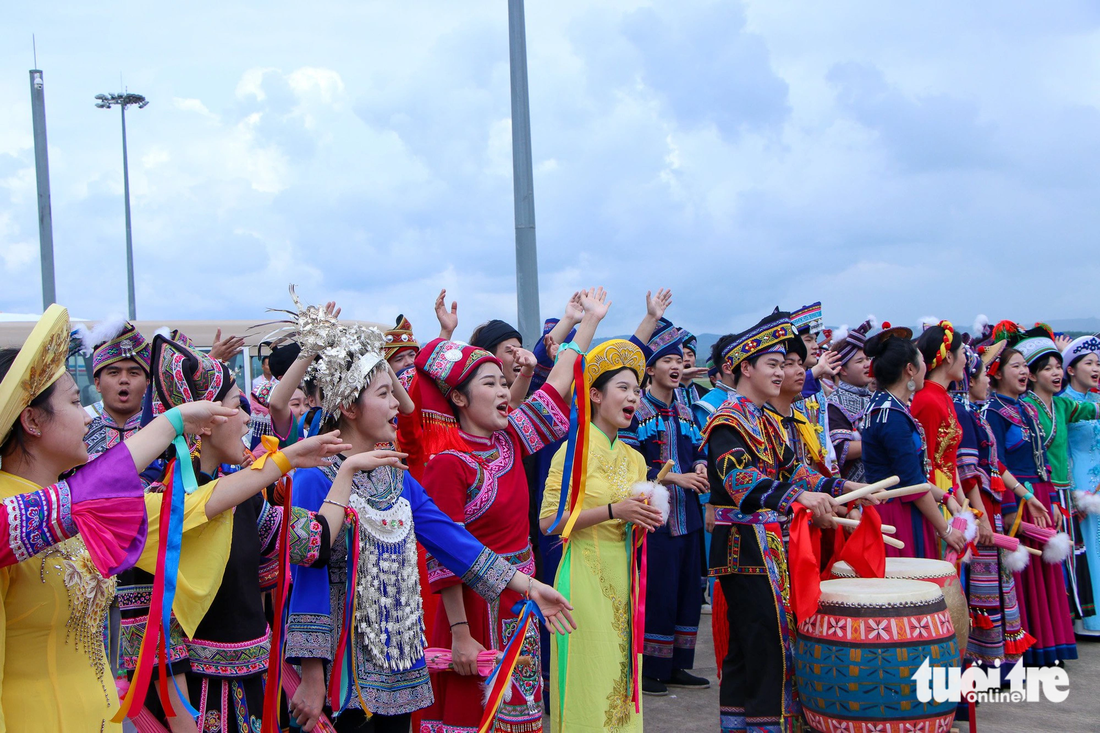 Các chàng trai, cô gái Quảng Tây trong trang phục truyền thống ca múa, vẫy tay chào Thủ tướng Phạm Minh Chính - Ảnh: DUY LINH