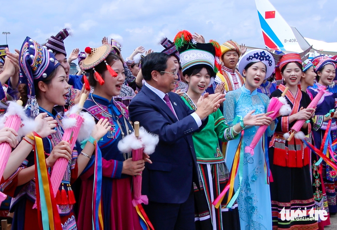 Thủ tướng Phạm Minh Chính hòa mình, vỗ tay cùng các chàng trai, cô gái Quảng Tây tại lễ tiễn ở sân bay - Ảnh: DUY LINH 
