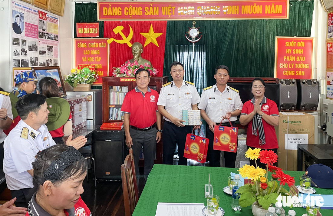 Bà Trần Kim Yến - chủ tịch Ủy ban MTTQ Việt Nam TP.HCM (bìa phải) - trao quà cho các chiến sĩ tại nhà giàn DK1 - Ảnh: CHÂU TUẤN