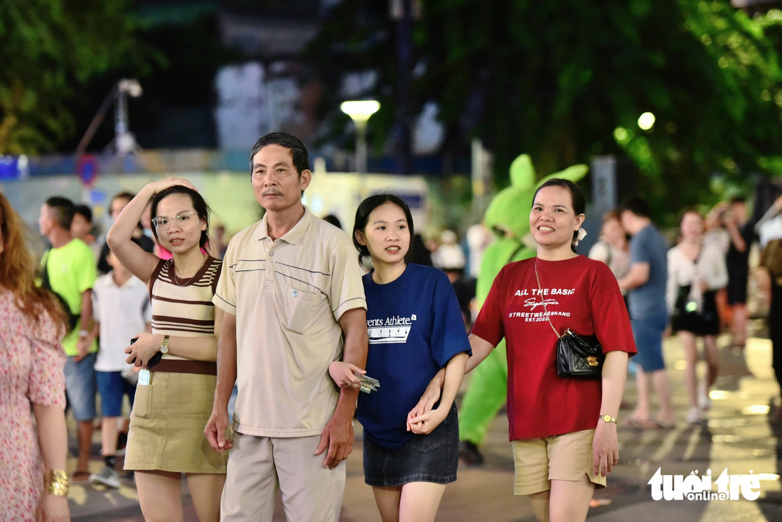 Gia đình chú Nguyễn Văn Liêm từ thành phố Thủ Đức lên phố đi bộ Nguyễn Huệ từ sớm để chờ ngắm pháo hoa - Ảnh: DUYÊN PHAN