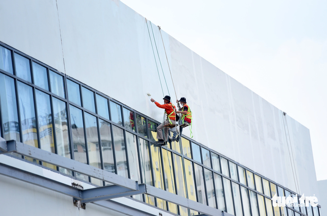 Công nhân tại công trình xây mới Bệnh viện Đa khoa khu vực Thủ Đức gấp rút sơn, sửa tòa nhà mới xây dựng để kịp tiến độ hoàn thành vào cuối năm 2023 - Ảnh: DUYÊN PHAN