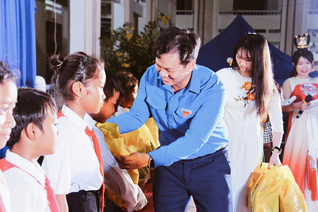 Anh Trần Anh Tuấn, bí thư Tỉnh đoàn Khánh Hòa, trao quà đến các em học sinh có hoàn cảnh khó khăn - Ảnh: TRẦN HOÀI