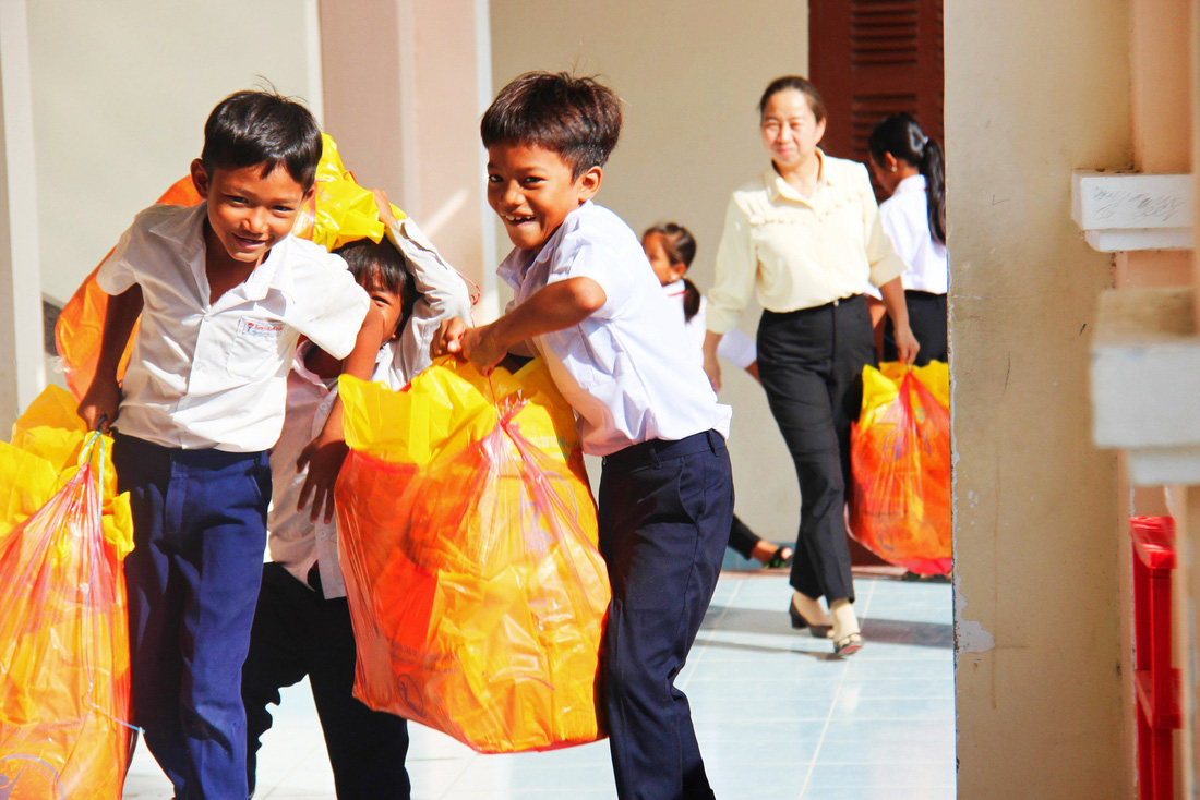 Các em học sinh Trường tiểu học Cam Thịnh Tây hồ hởi mang quà Trung thu về lớp - Ảnh: TRẦN HOÀI