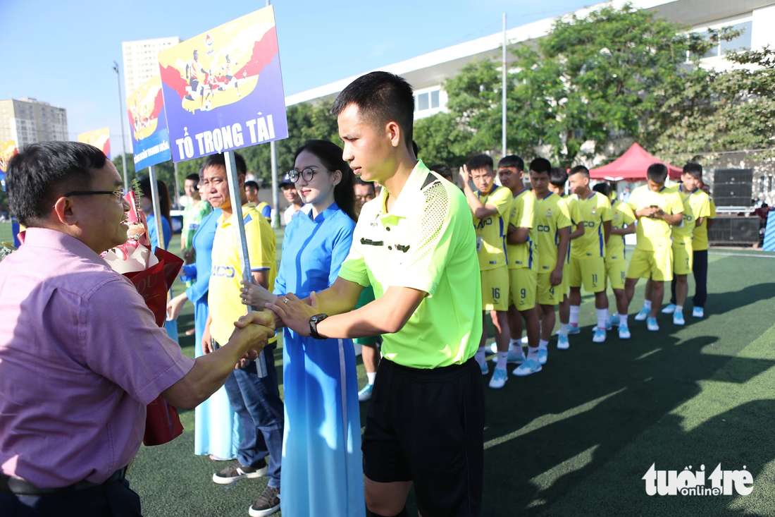 Ông Ngọc Kim Nam - trưởng Ban Dân vận tỉnh ủy Nghệ An - tặng hoa chúc mừng các đội bóng, tổ trọng tài - Ảnh: HOÀNG TÙNG