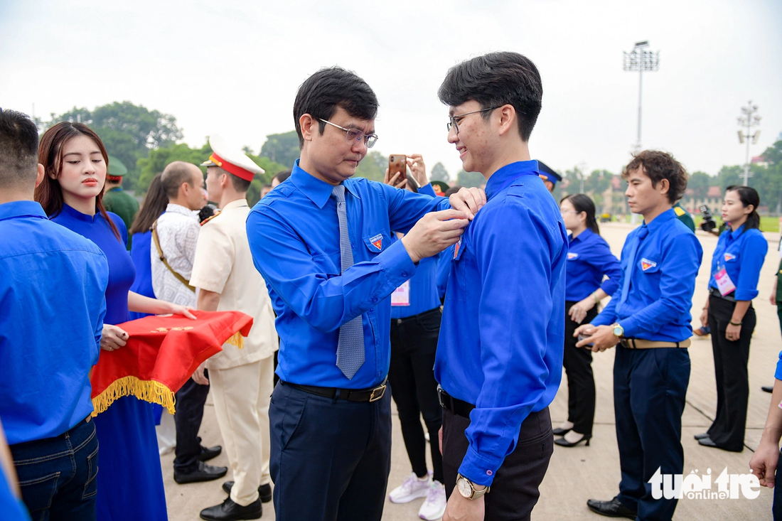 Anh Bùi Quang Huy - bí thư thứ nhất Trung ương Đoàn - trao huy hiệu Thanh niên tiên tiến làm theo lời Bác cho các đoàn viên tiêu biểu