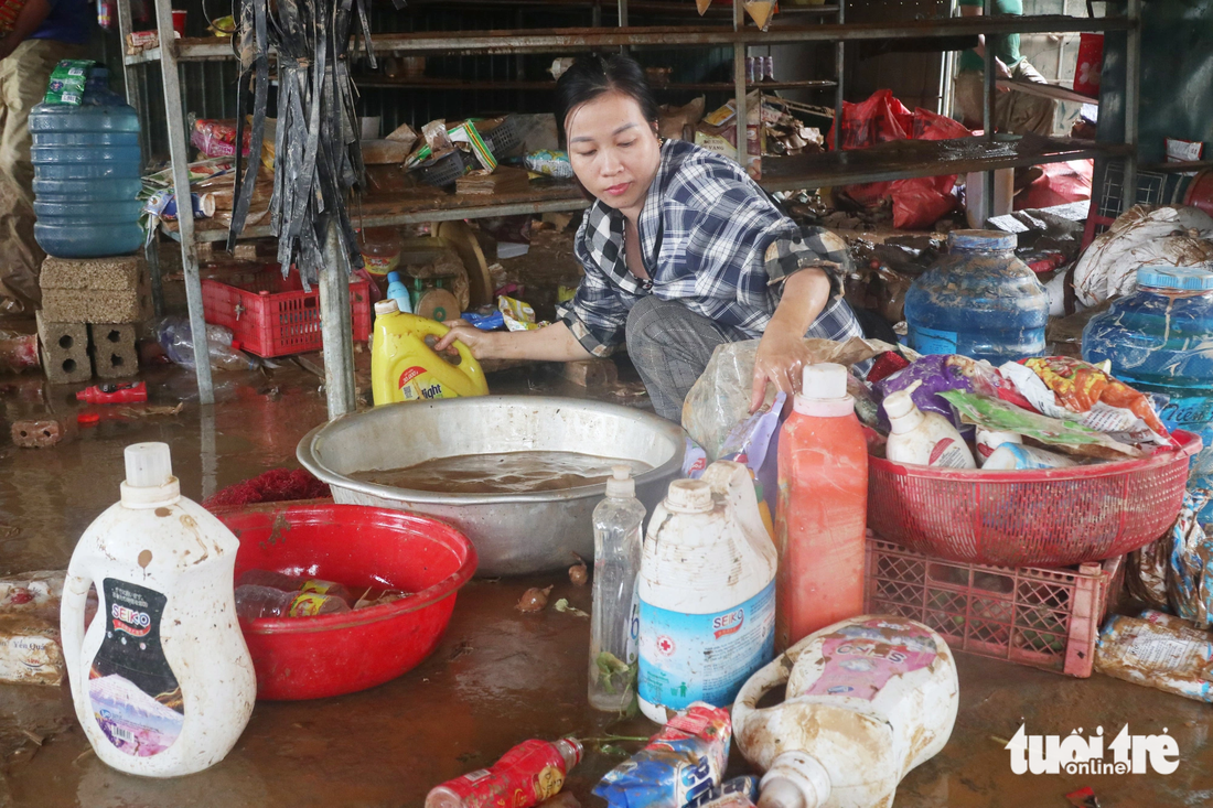 Chị Võ Thị Phương - 37 tuổi, ngụ xã Châu Hạnh, huyện Quỳ Châu, Nghệ An - tìm hàng hóa còn sót lại sau mưa lũ - Ảnh: DOÃN HÒA