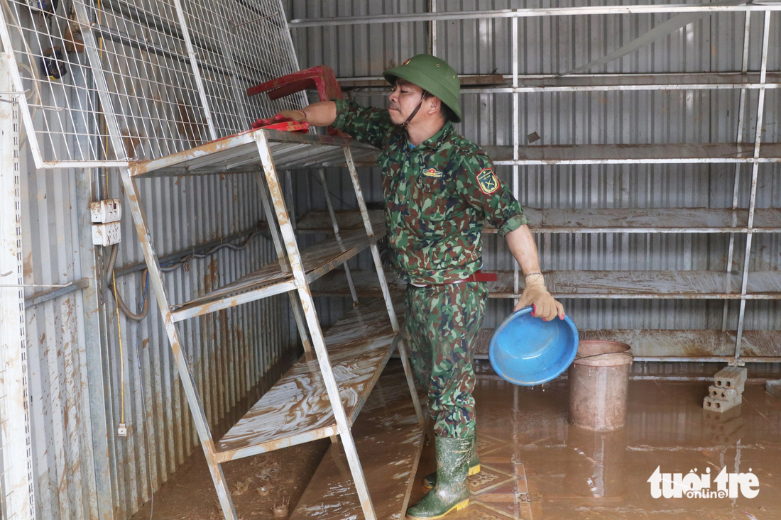 Lực lượng bộ đội hỗ trợ người dân dọn dẹp nhà cửa sau khi nước lũ rút - Ảnh: DOÃN HÒA