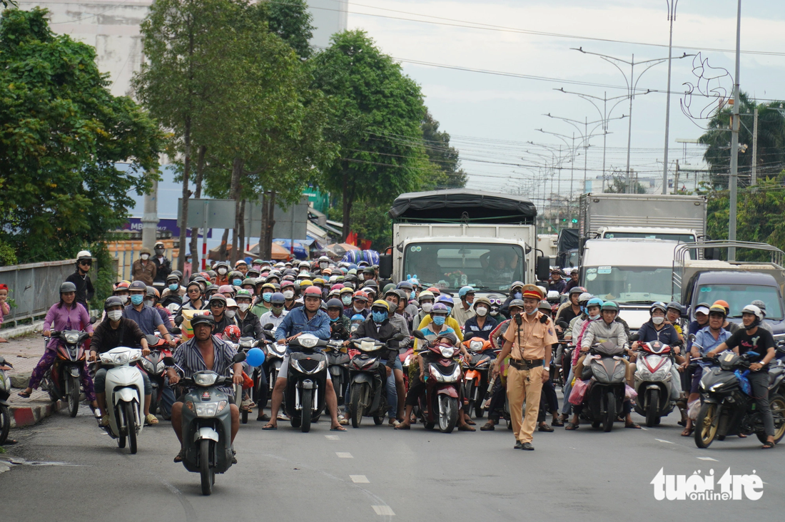Cảnh sát giao thông tỉnh Tiền Giang phải chặn dòng xe từ Tiền Giang qua Bến Tre để ưu tiên cho dòng xe hướng ngược lại qua cầu Rạch Miễu trong buổi chiều 3-9 - Ảnh: MẬU TRƯỜNG