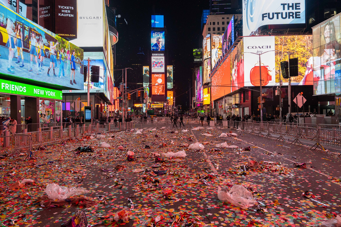 Rác và vụn hoa giấy tràn ngập đường phố sau lễ đón giao thừa - Ảnh: AFP