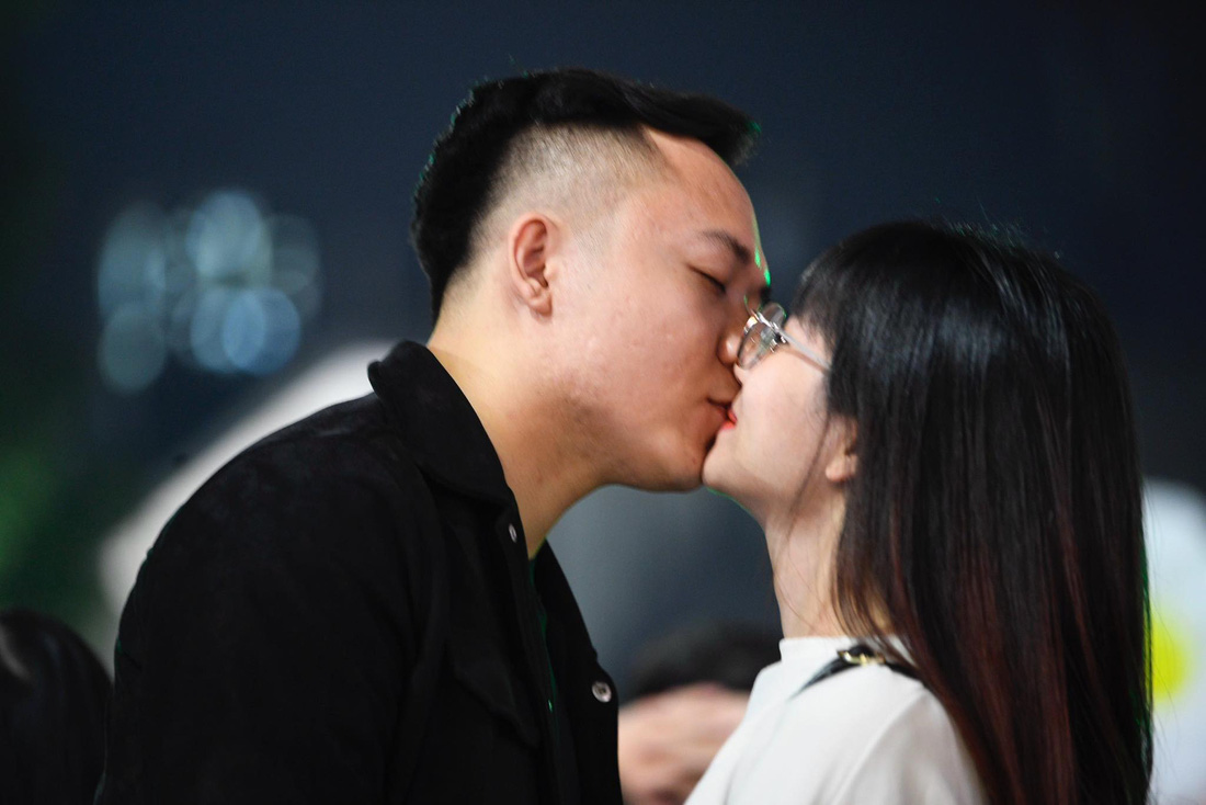 Một đôi bạn trẻ trao cho nhau nụ hôn khi bước sang năm mới 2024, ảnh chụp tại Hồ Hoàn Kiếm, Hà Nội - Ảnh: HUY QUÂN