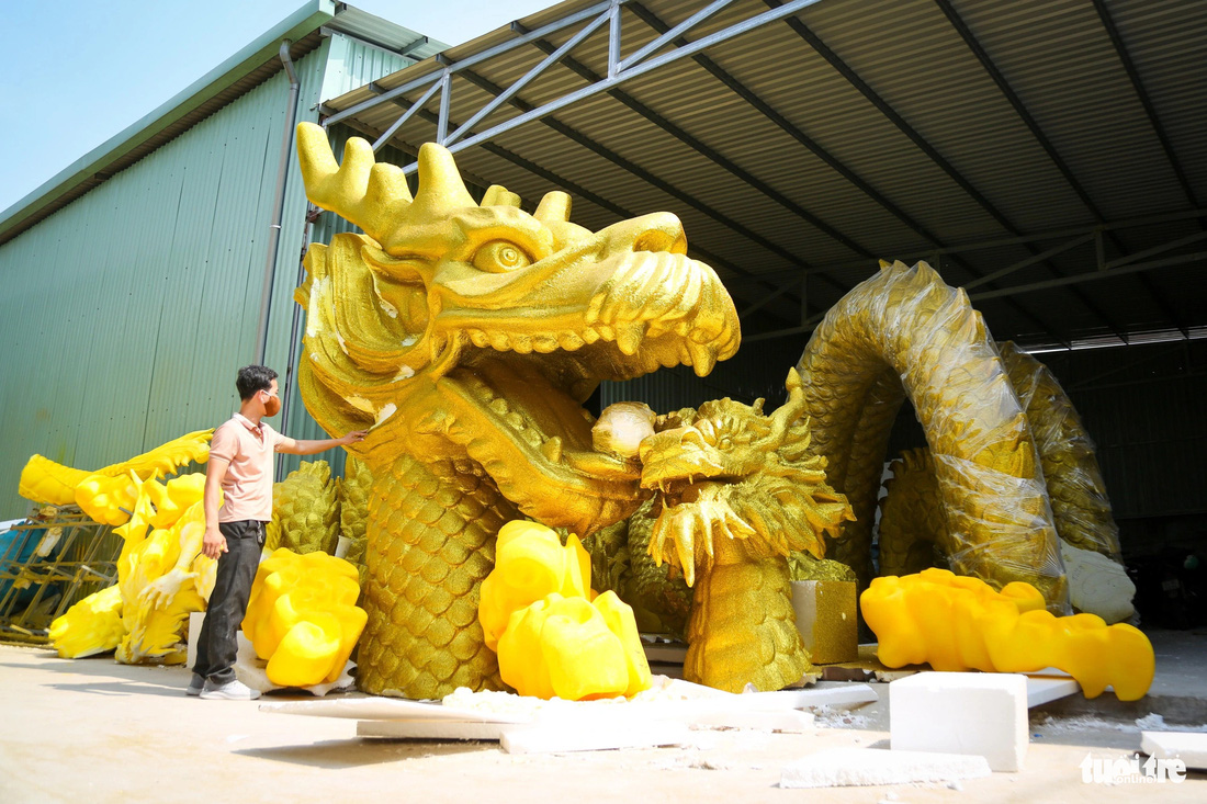 Anh Phan Chí Linh (quản lý sản xuất của xưởng) kiểm tra lại mẫu linh vật rồng sắp hoàn thiện để giao cho khách ở Vũng Tàu - Ảnh: PHƯƠNG QUYÊN