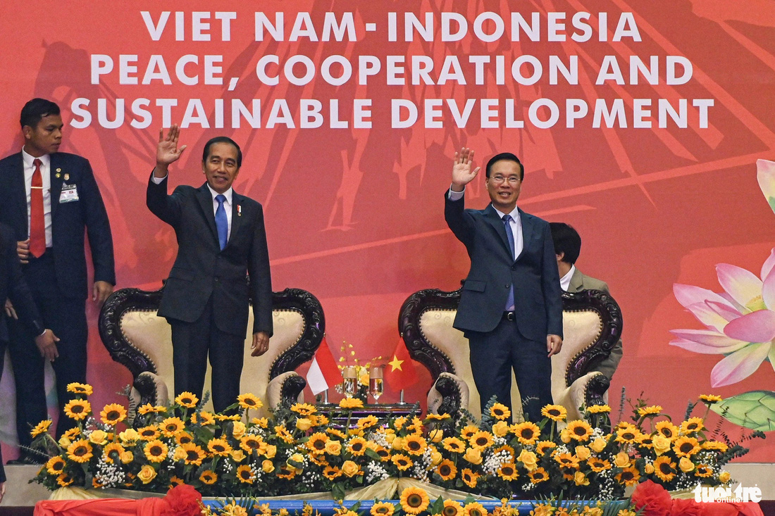 Chủ tịch nước Võ Văn Thưởng và Tổng thống Indonesia Joko Widodo vẫy tay chào các vận động viên cùng người dân khi đến Cung thể thao Quần Ngựa - Ảnh: HỒNG QUANG