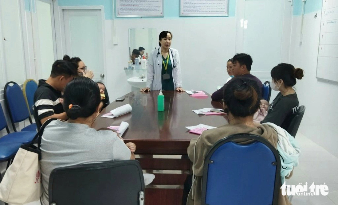 Trưởng Trạm y tế phường Bình Trưng Tây đang giải thích cho phụ huynh về ý nghĩa tiêm vắc xin, quy trình tiêm vắc xin - Ảnh: M.T.