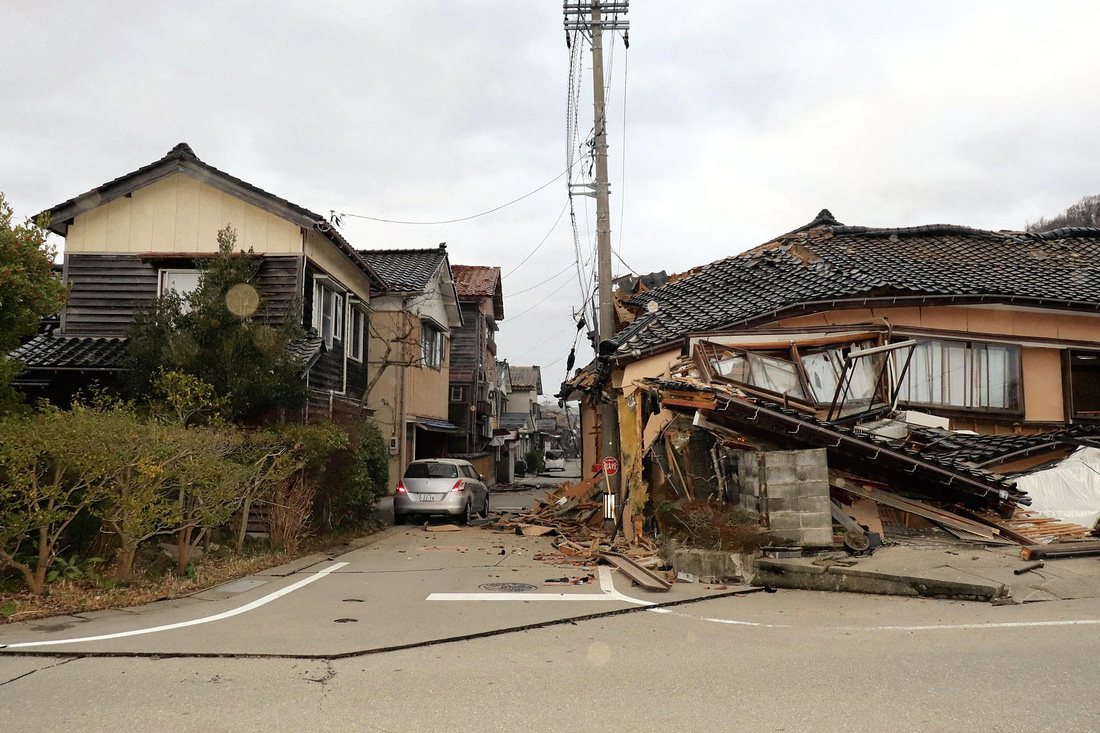 Một nhà dân tại thành phố Wajima bị sụp đổ hoàn toàn, trong khi dãy nhà đối diện còn tương đối nguyên vẹn - Ảnh: AFP