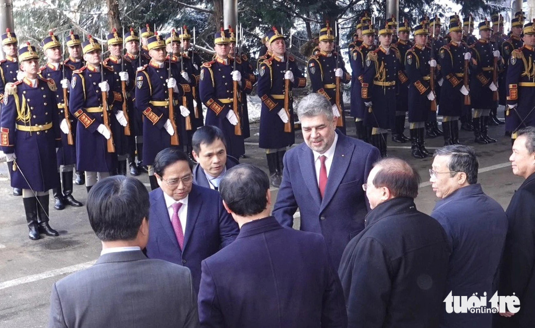 Thủ tướng Phạm Minh Chính giới thiệu các quan chức Việt Nam với Thủ tướng Romania Marcel Ciolacu - Ảnh: Q.TR.