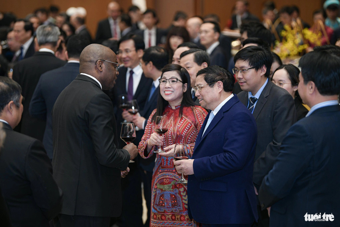 Thủ tướng Phạm Minh Chính và phu nhân trò chuyện với một nhà ngoại giao nước ngoài tại tiệc chiêu đãi - Ảnh: NAM TRẦN