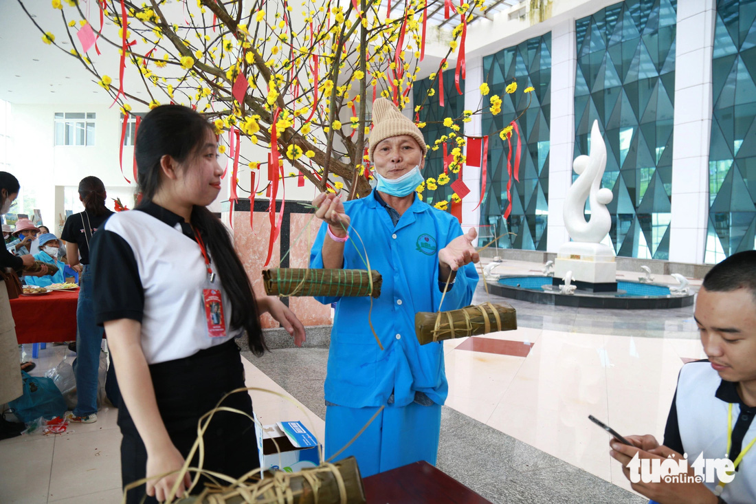 Ông Trương Văn Quý (69 tuổi, quê Đắk Lắk) xúc động khi được cùng mọi người gói và nấu rồi thưởng thức bánh tét ngay tại bệnh viện - Ảnh: ĐOÀN NHẠN
