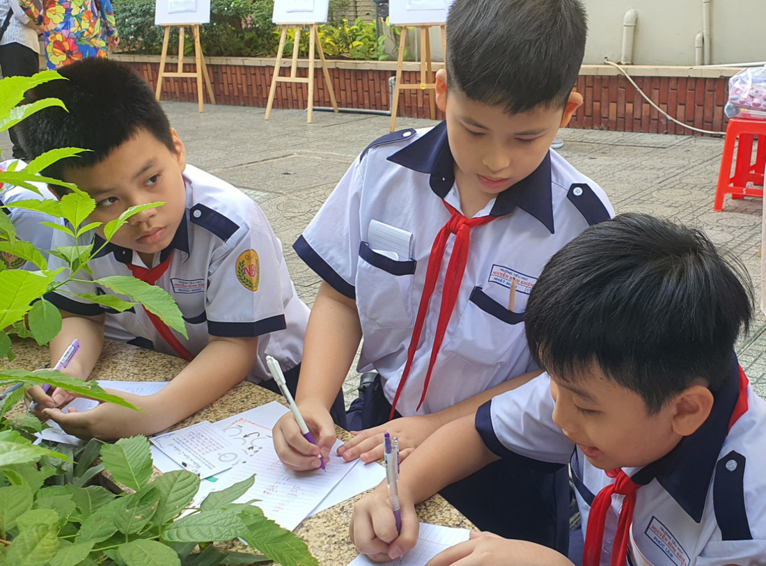 Học sinh đến các bồn cây trong sân trường và giải quyết yêu cầu tính diện tích thành bồn cây - Ảnh: HOÀNG HƯƠNG