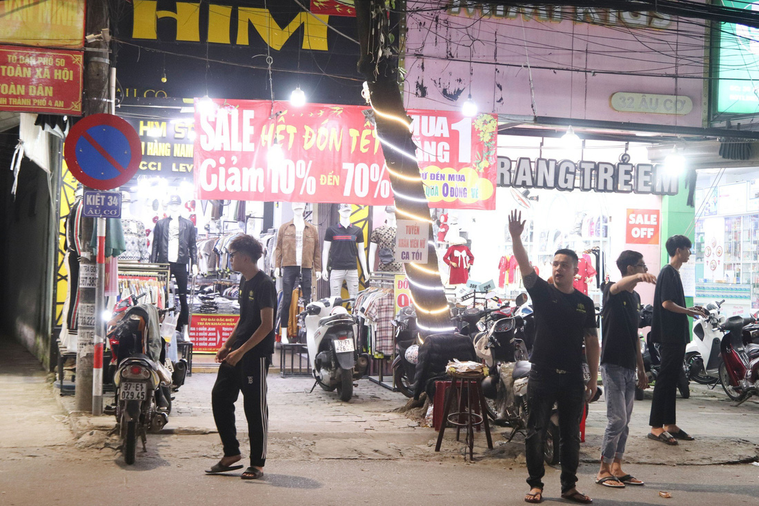 Toàn bộ nhân viên của cửa hàng HIM (34 Âu Cơ, Q. Liên Chiểu, Đà Nẵng) tràn ra đường mời gọi khách hàng - Ảnh: THANH NGUYÊN