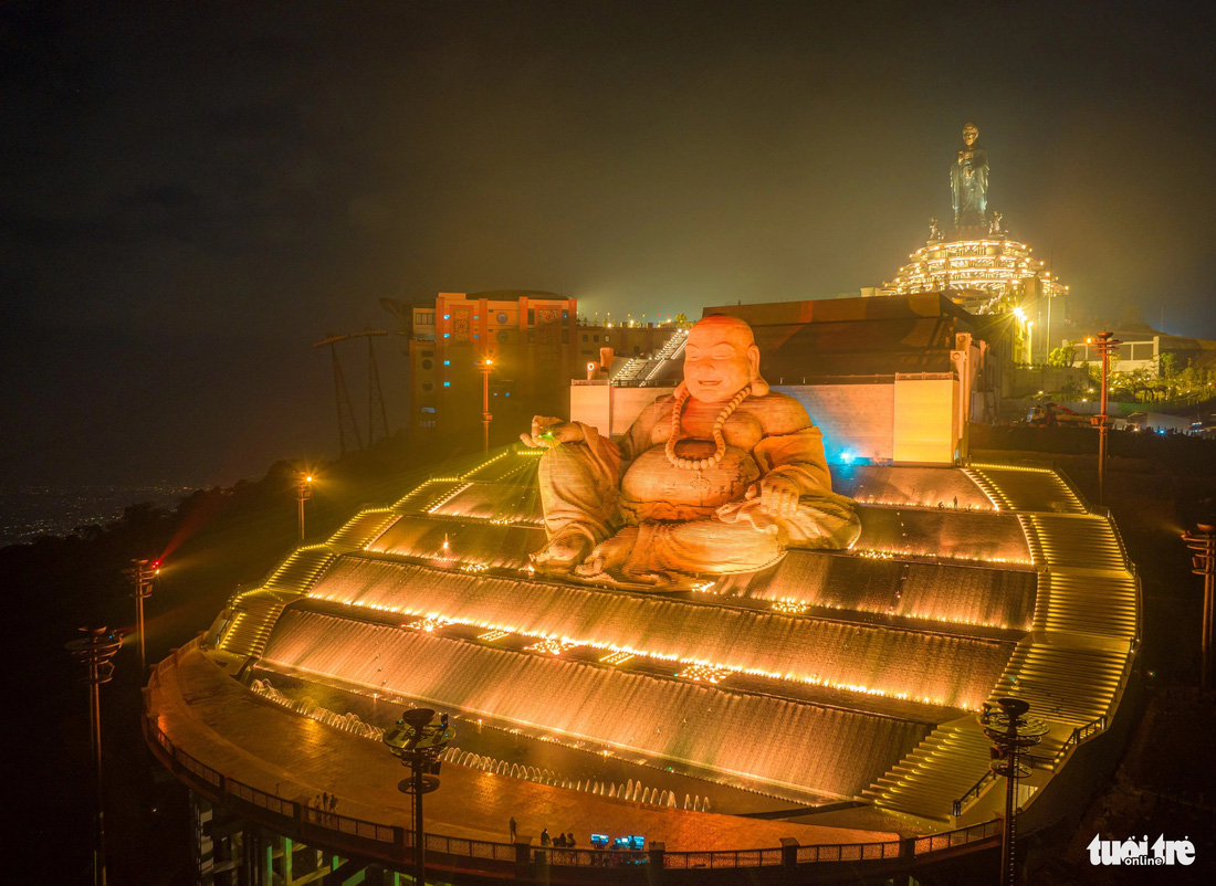 Vào buổi tối, tượng Phật Di Lặc lung linh bởi sự thắp sáng của hệ thống đèn phối hợp đài phun nước - Ảnh: CHÂU TUẤN