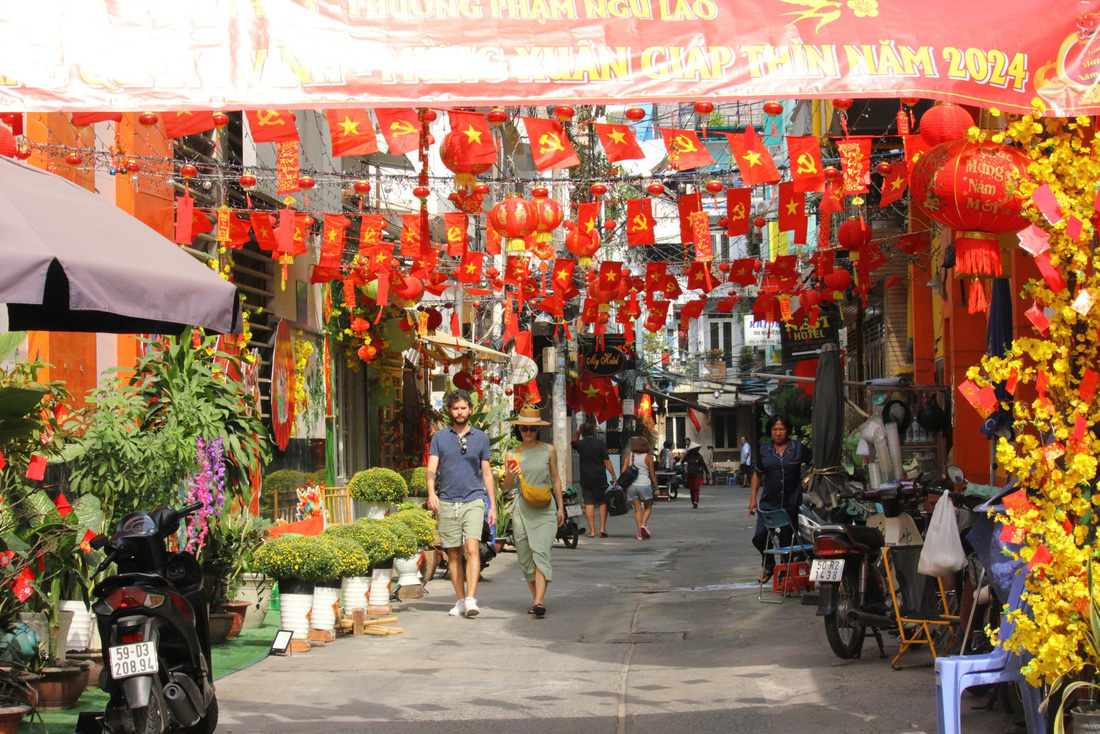 Hẻm 100 đường Trần Hưng Đạo (phường Phạm Ngũ Lão, quận 1) được người dân trang hoàng rực rỡ cờ hoa - Ảnh: BÉ HIẾU