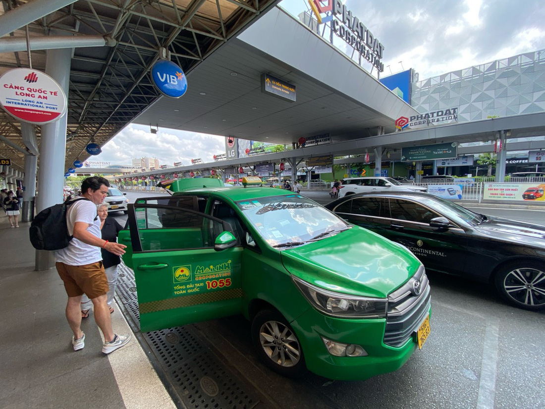 Hành khách sử dụng dịch vụ taxi ở sân bay Tân Sơn Nhất - Ảnh: QUANG ĐỊNH
