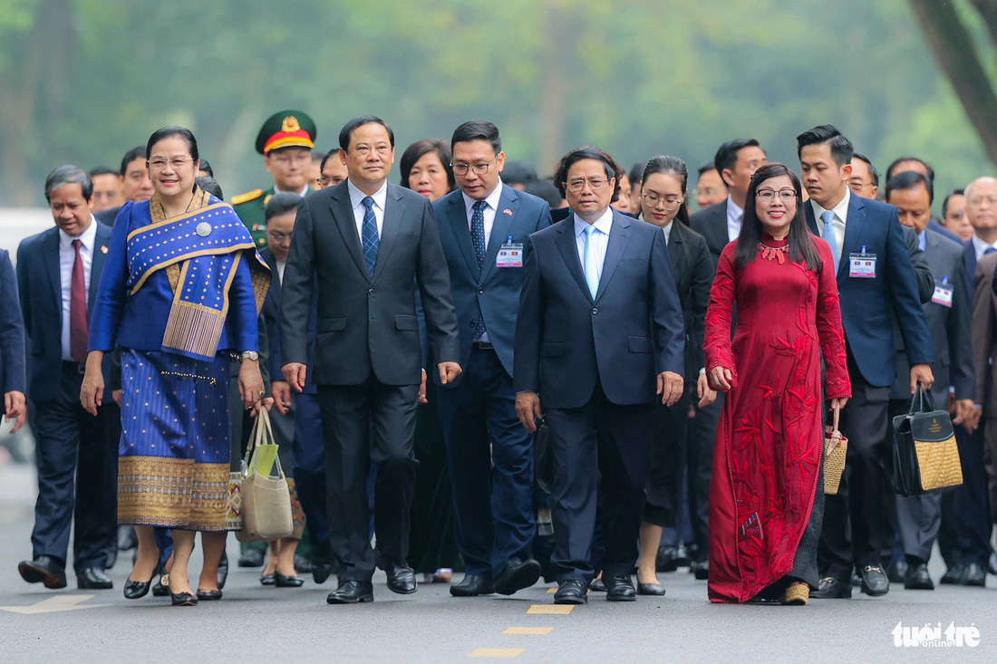 Hai Thủ tướng và phu nhân cùng đi bộ về nơi hội đàm sau lễ đón - Ảnh: NGUYỄN KHÁNH