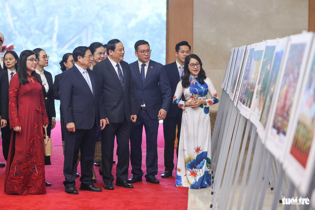 Thủ tướng Phạm Minh Chính và phu nhân cùng Thủ tướng Lào Sonexay Siphandone và phu nhân xem triển lãm ảnh về quan hệ hai nước - Ảnh: NGUYỄN KHÁNH