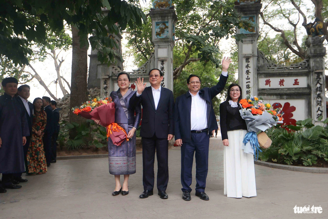 Hai Thủ tướng và phu nhân vẫy tay chào người dân trước khi vào tham quan đền Ngọc Sơn - Ảnh: NGUYỄN KHÁNH
