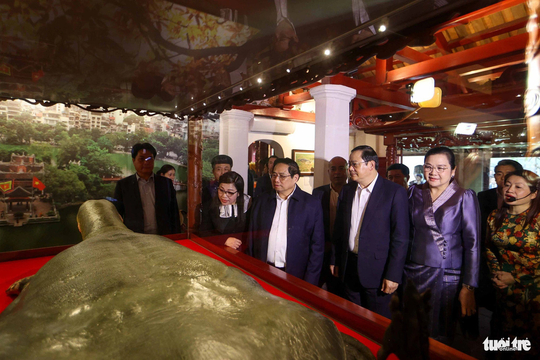Thủ tướng Phạm Minh Chính và phu nhân cùng Thủ tướng Lào Sonexay Siphandone và phu nhân nghe giới thiệu về tiêu bản rùa hồ Gươm - Ảnh: NGUYỄN KHÁNH