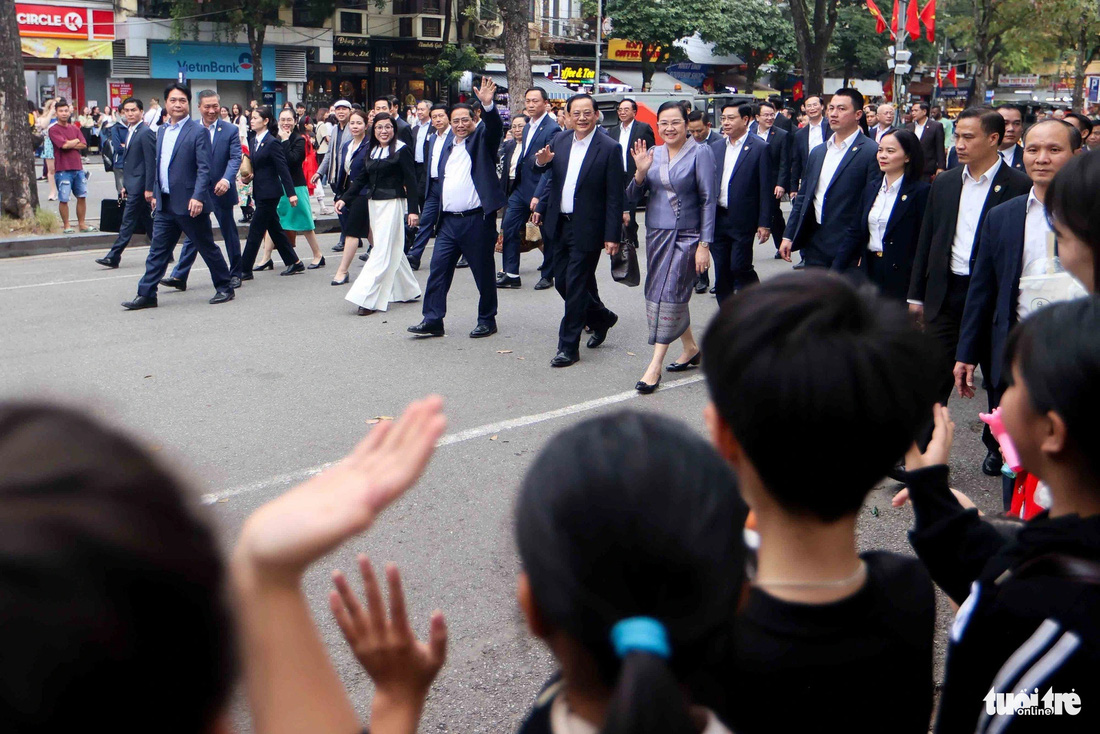 Nhiều người dân Việt Nam vẫy tay chào mừng khi hai nhà lãnh đạo và phu nhân đi qua - Ảnh: NGUYỄN KHÁNH