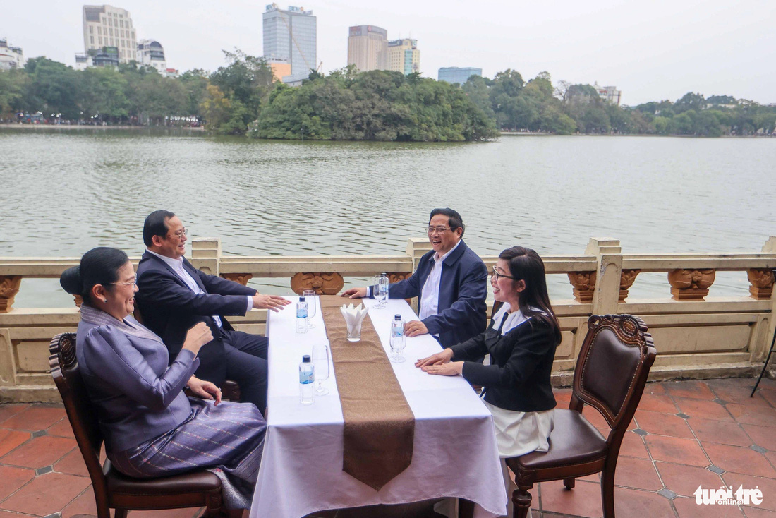 Thủ tướng Phạm Minh Chính và phu nhân cùng Thủ tướng Lào Sonexay Siphandone và phu nhân trò chuyện, uống cà phê bên hồ Gươm - Ảnh: NGUYỄN KHÁNH