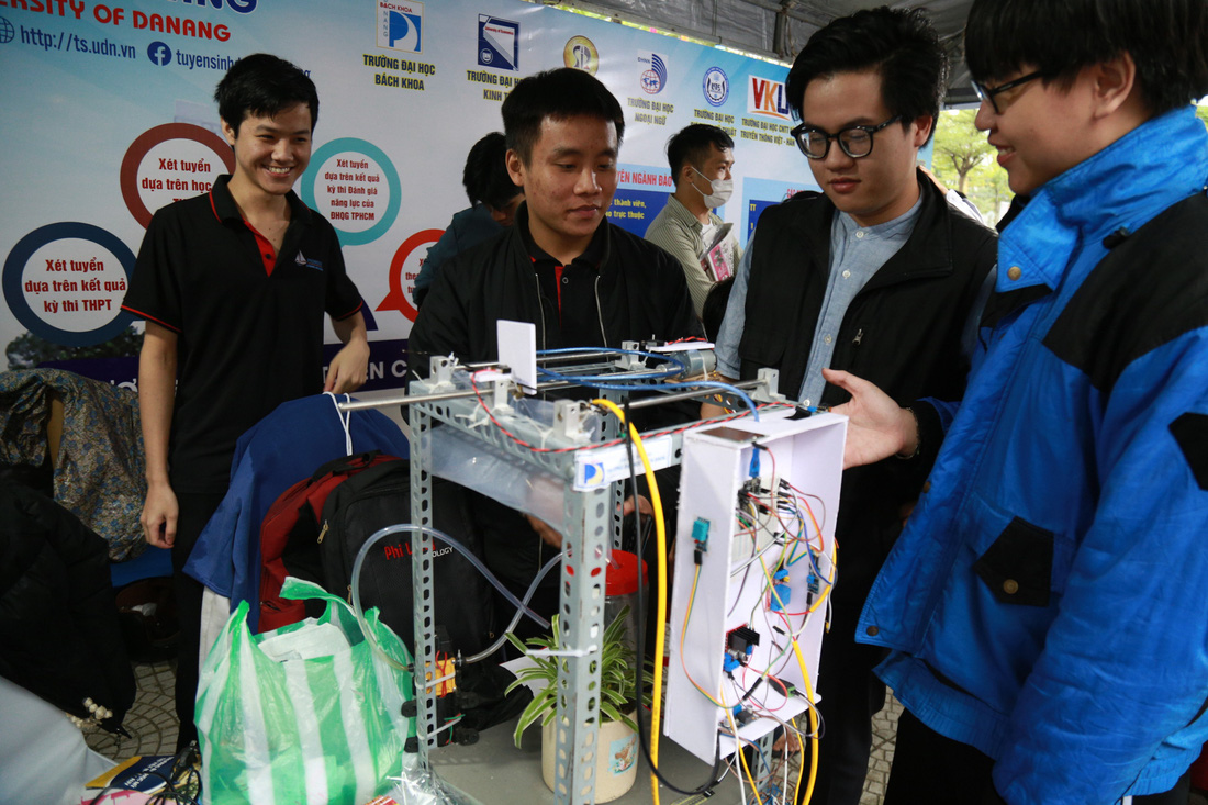 Nguyễn Văn Phú Đạt (thứ 2 bên phải, Trường THPT Trần Phú, Đà Nẵng) hào hứng tham quan gian hàng trưng bày mô hình nghiên cứu khoa học của Trường đại học Bách khoa Đà Nẵng - Ảnh: ĐOÀN NHẠN