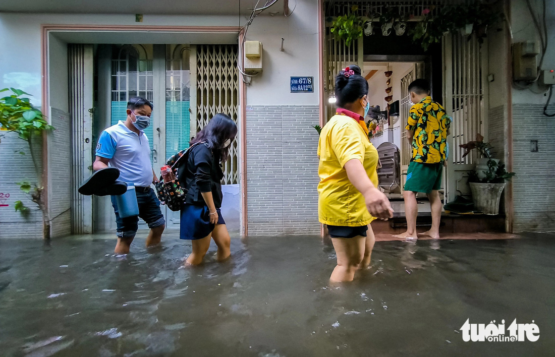 Quận 7 ngập cả mét vì triều cường, người ra khách sạn ở, người cõng con đi học - Ảnh 15.