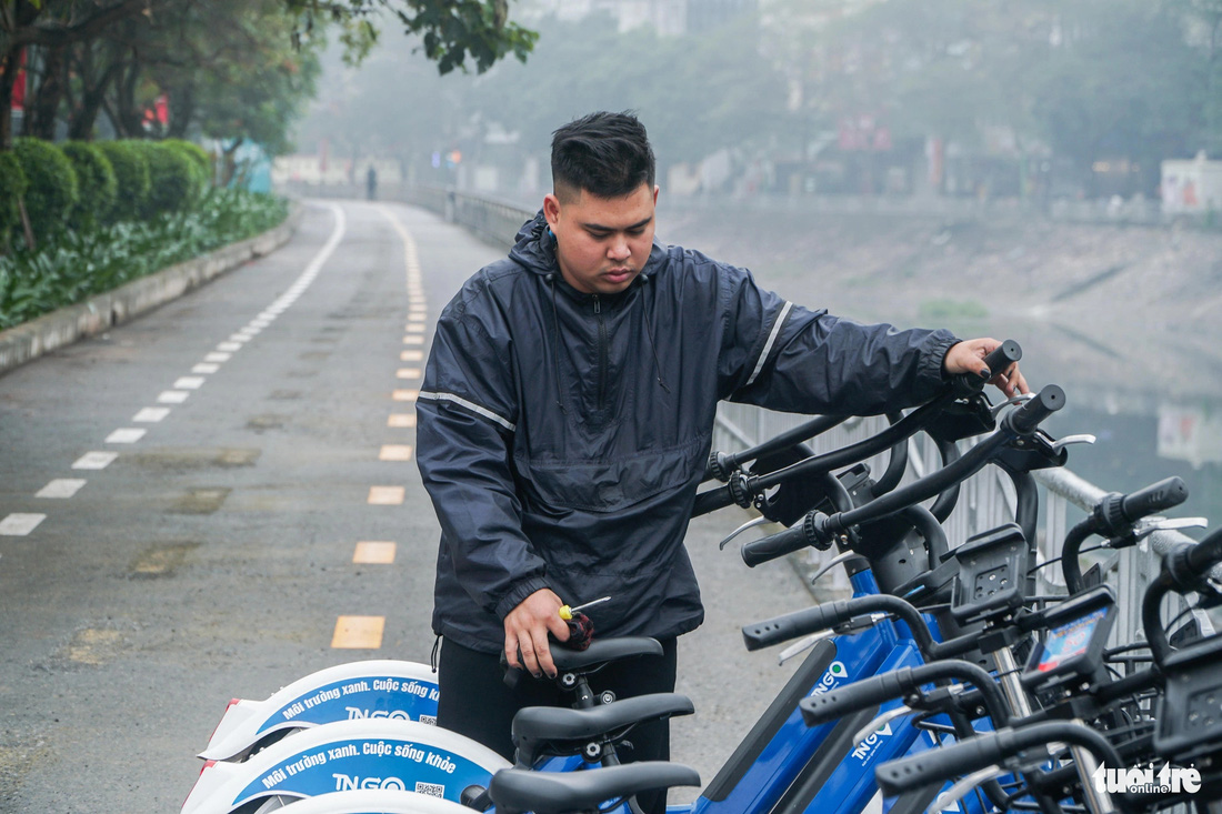 Một kỹ thuật viên kiểm tra lại hệ thống phanh của xe đạp trước khi người dân trải nghiệm - Ảnh: PHẠM TUẤN
