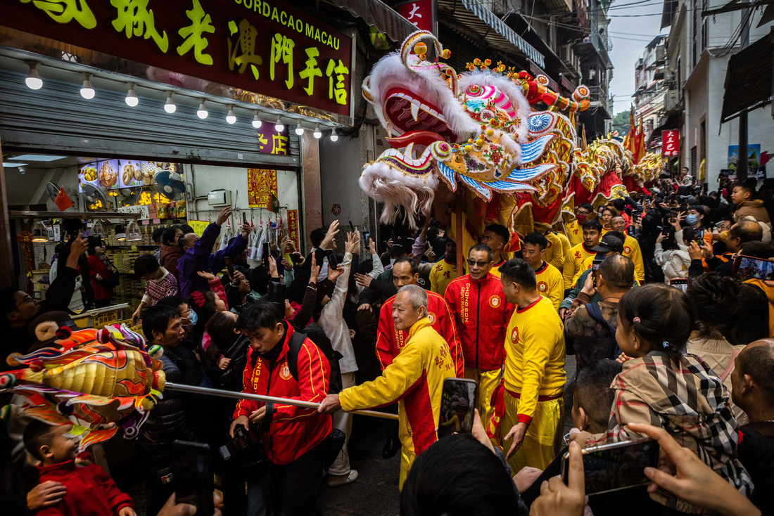Đoàn lân sư rồng được người dân đón nhận nhiệt thành trên đường phố Macau, Trung Quốc vào sáng mùng 1 Tết - Ảnh: AFP