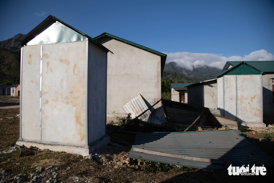 Nhà vệ sinh mới xây (trái) bên cạnh một gian bếp đổ nát do người dân bỏ về nơi ở cũ - Ảnh: HOÀNG TÁO