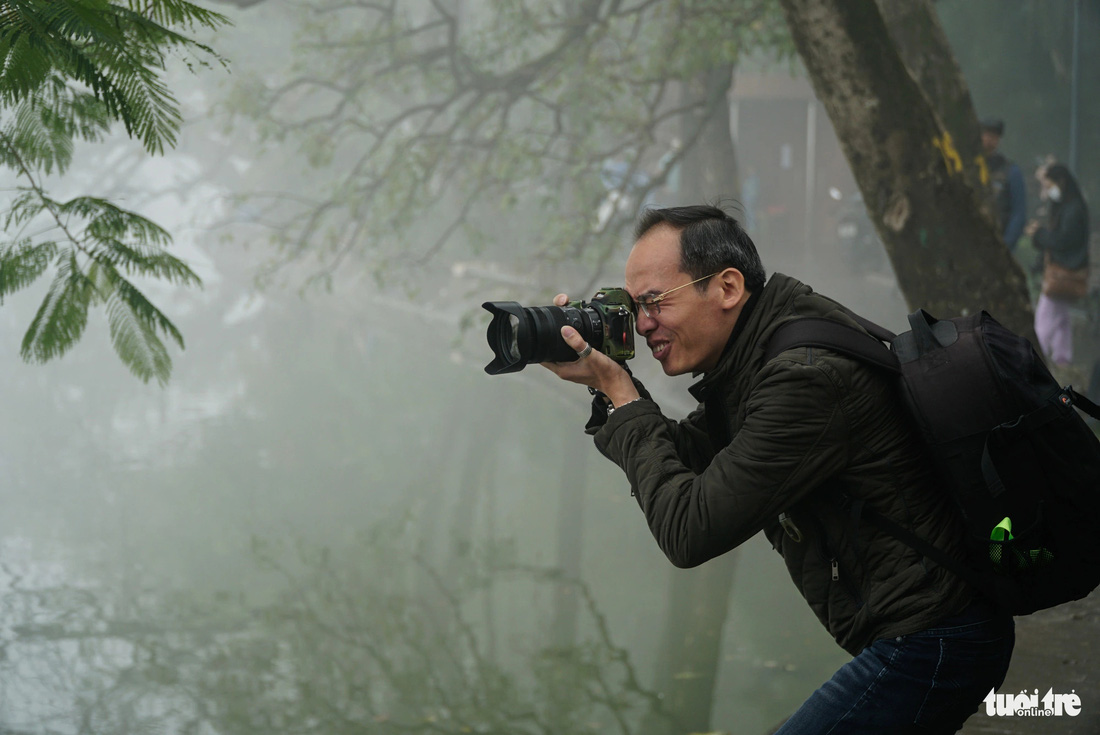 Nhiều nhiếp ảnh gia có mặt từ sớm để săn ảnh tháp Rùa ẩn hiện trong màn sương - Ảnh: NGUYỄN HIỀN
