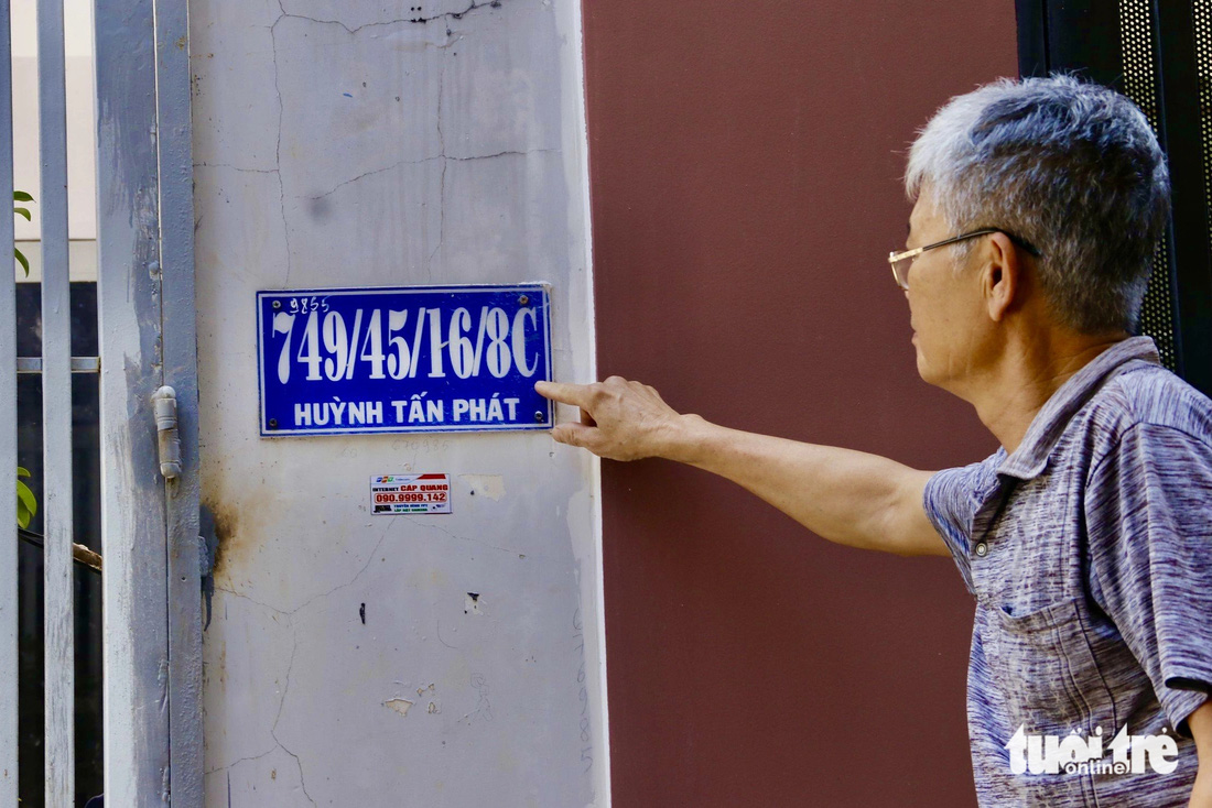 Một người dân ngụ trên đường Huỳnh Tấn Phát (quận 7, TP.HCM) chỉ tay vào biển số nhà có 4 xuyệt nối dài - Ảnh: TIẾN QUỐC