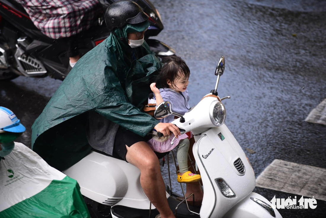 Cơn mưa chợt kéo đến bất ngờ nên người đi đường không kịp chuẩn bị - Ảnh: QUANG ĐỊNH