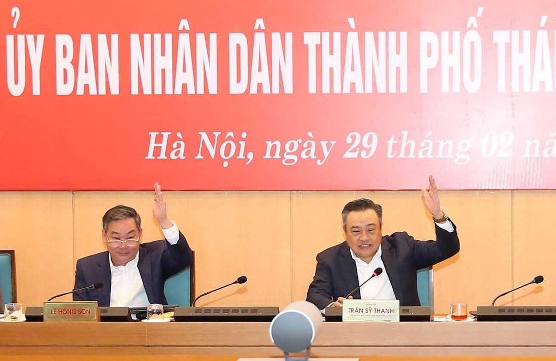 Chủ tịch UBND TP Hà Nội Trần Sỹ Thanh và Phó chủ tịch Lê Hồng Sơn giơ tay biểu quyết tại phiên họp sáng 29-2 - Ảnh: UBND TP 
